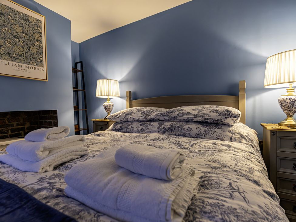 A bedroom with a bed and bedside lamp at The Gardeners Cottage in Lytham St. Annes
