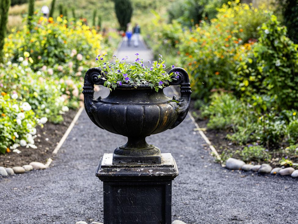 A flower pot with flowers in a garden at The Gardeners Cottage at Lytham Hall Lytham St. Annes