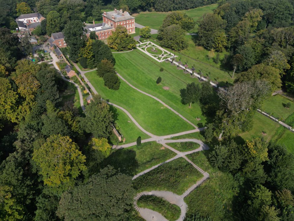 An outdoor park with a building and pathways at The Gardeners Cottage at Lytham Hall Lytham St. Annes