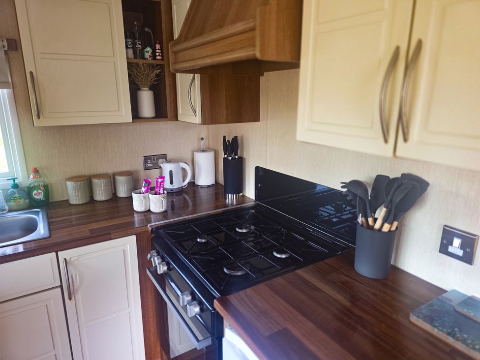 A kitchen with cabinets and stove at Caravan 1 at Blackmoor Farm near Tenby