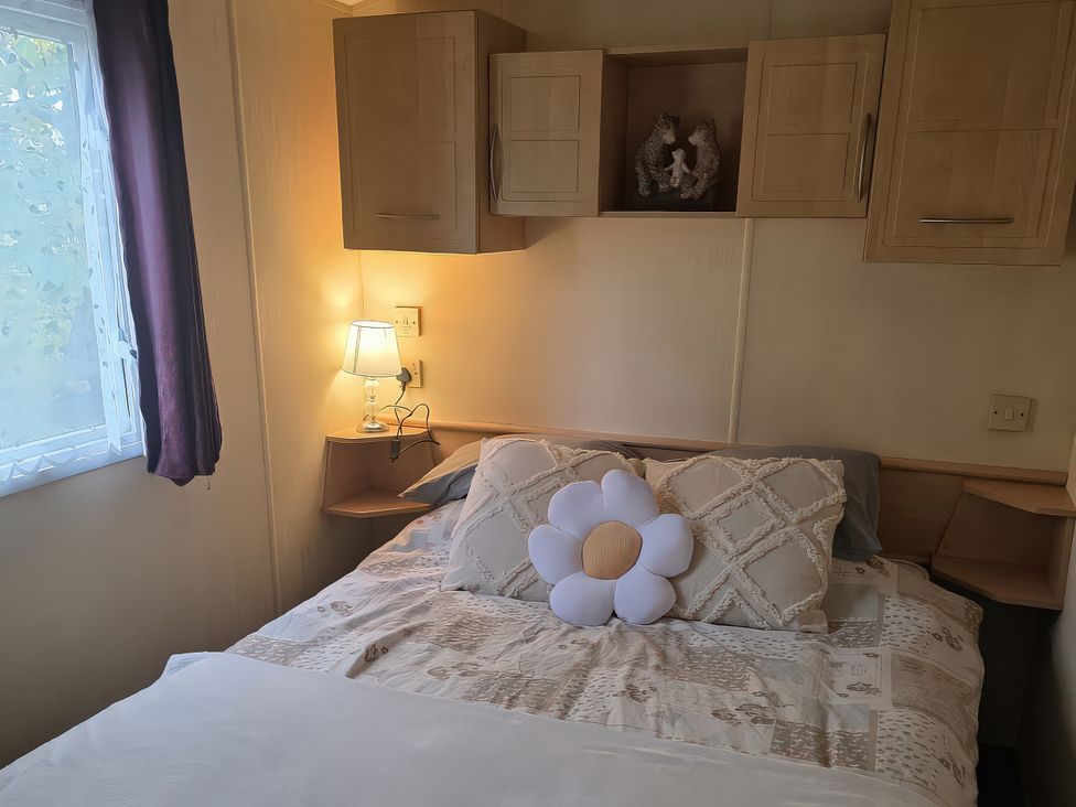 A bedroom with a double bed and lamp at Caravan 1 at Blackmoor Farm near Tenby Narberth