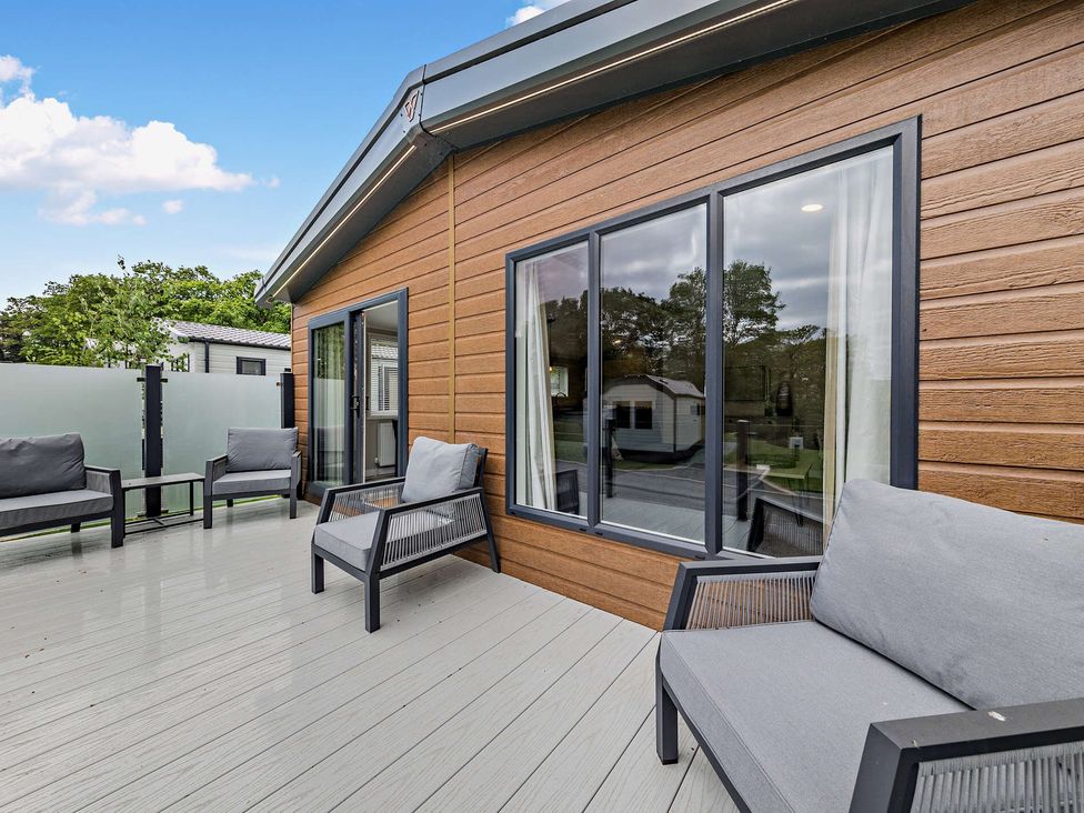 A deck with outdoor furniture and windows at Saron 2.0 Pet in Llandyrnog