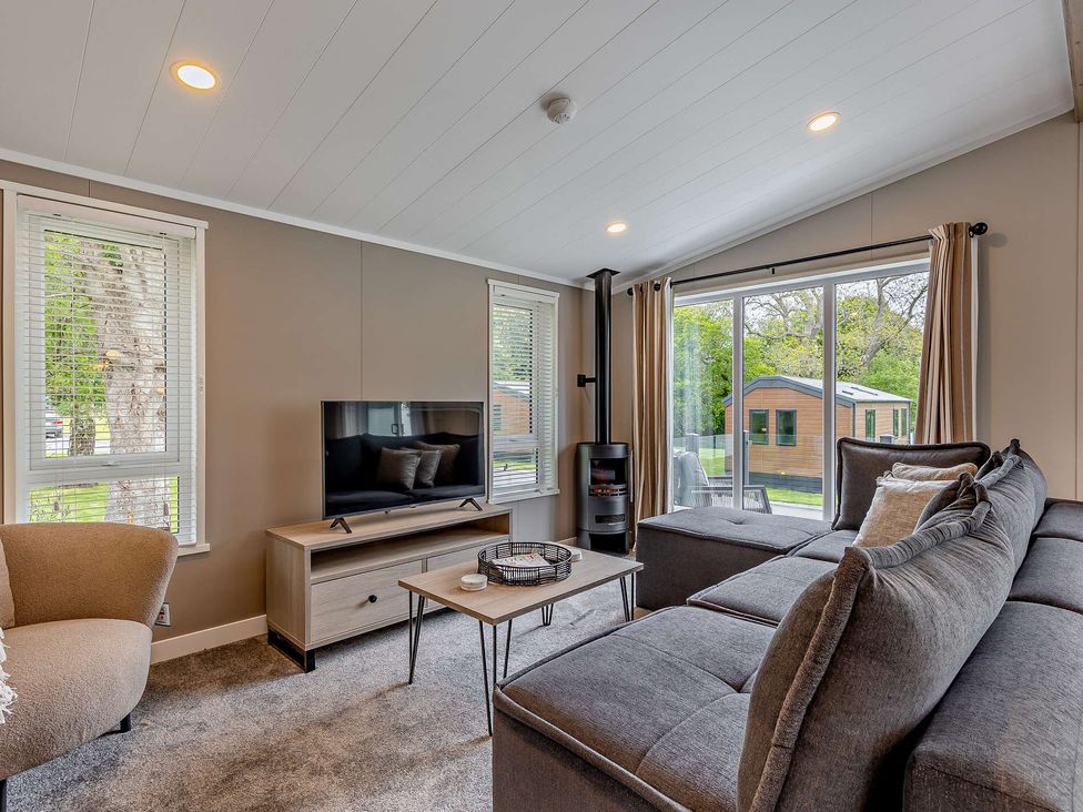 A living room with a sofa and television at Saron 2.0 Pet in Llandyrnog