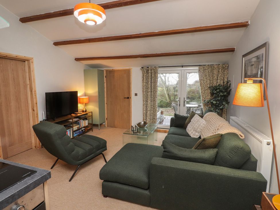 A living room with a sofa and television at 20 Chatham Log Cabins in Caernarfon