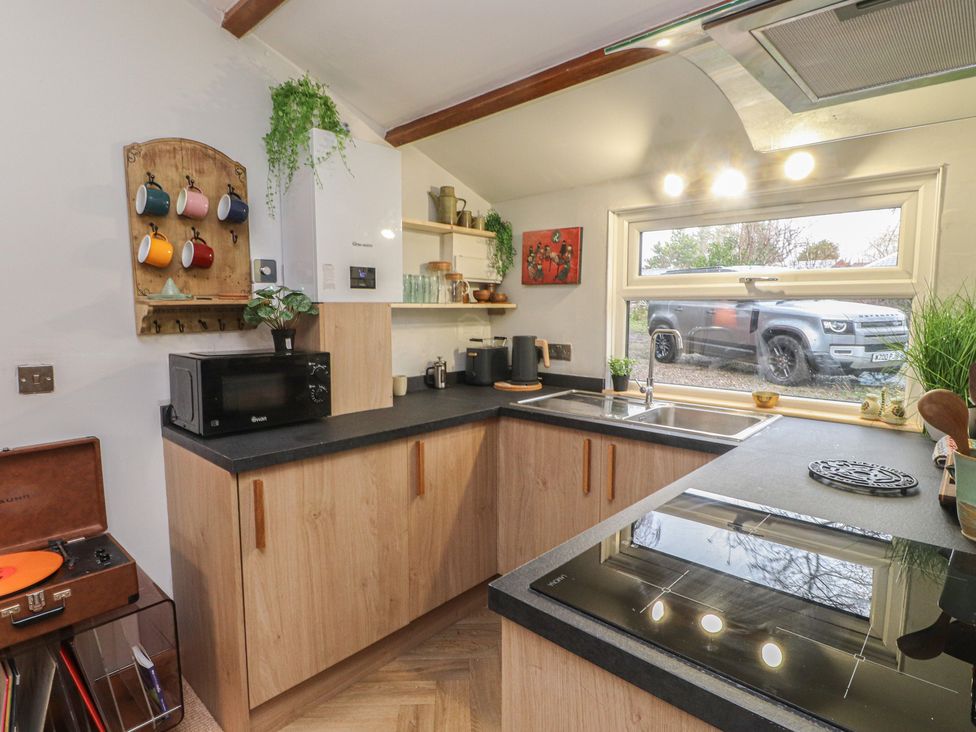 A kitchen with cabinets and appliances at 20 Chatham Log Cabins in Caernarfon