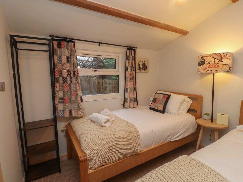 A bedroom with two beds and a lamp at 20 Chatham Log Cabins, Caernarfon