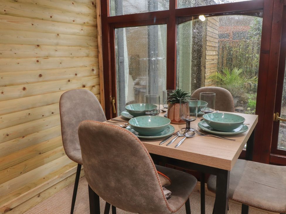 A dining room with a table set for four at 20 Chatham Log Cabins Caernarfon