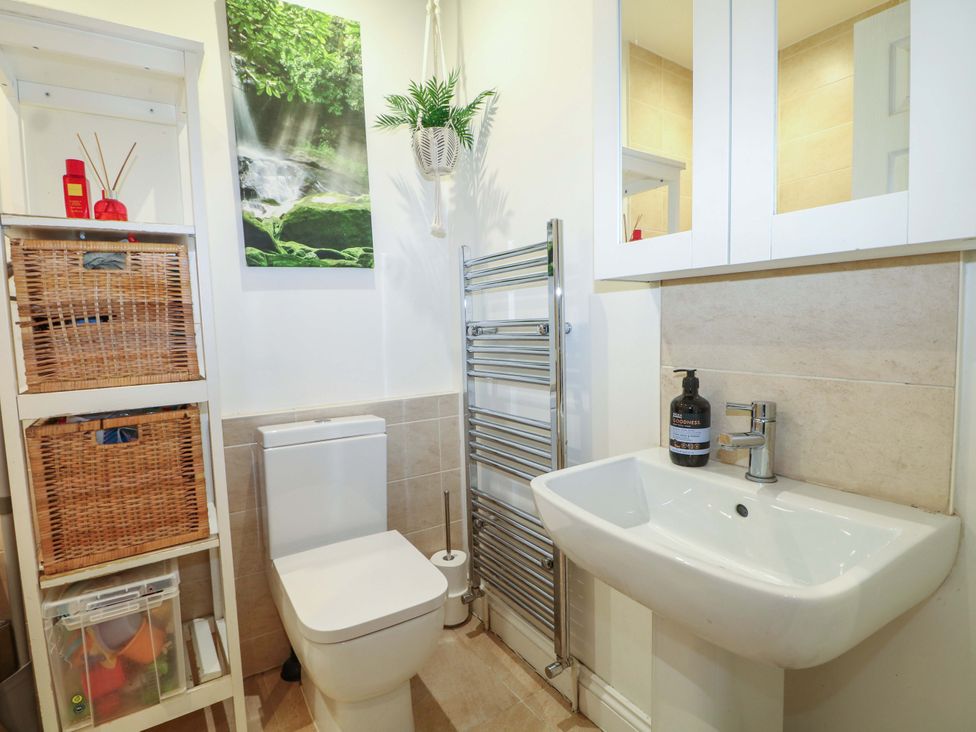 A bathroom with a toilet, sink, and storage at 213 Gordon Avenue Camberley