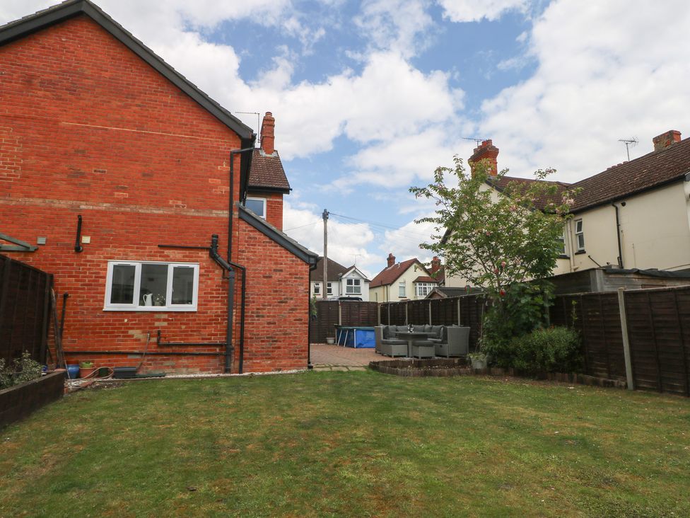 A garden with a house and patio furniture at Gordon Avenue in Camberley