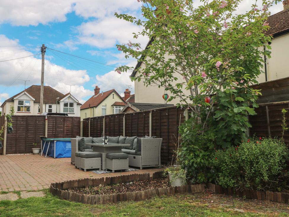 A garden with a patio sofa set and a pool at Gordon Avenue in Camberley