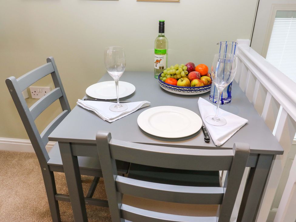 A dining table with fruit and tableware at Chapel House Annex in Scholes