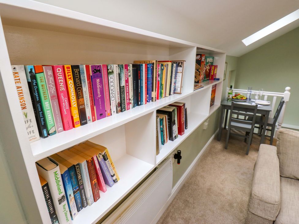 A living room with a bookshelf and dining area at Chapel House Annex Scholes