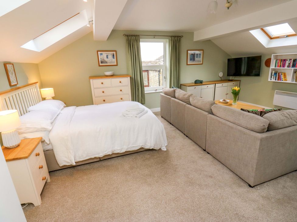 A bedroom with a bed, sofa, and television at Chapel House Annex Scholes