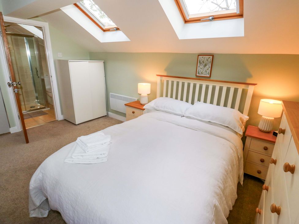 A bedroom with a bed and ensuite shower at Chapel House Annex in Scholes