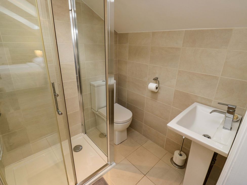 A bathroom with a shower, toilet, and sink at Chapel House Annex in Scholes