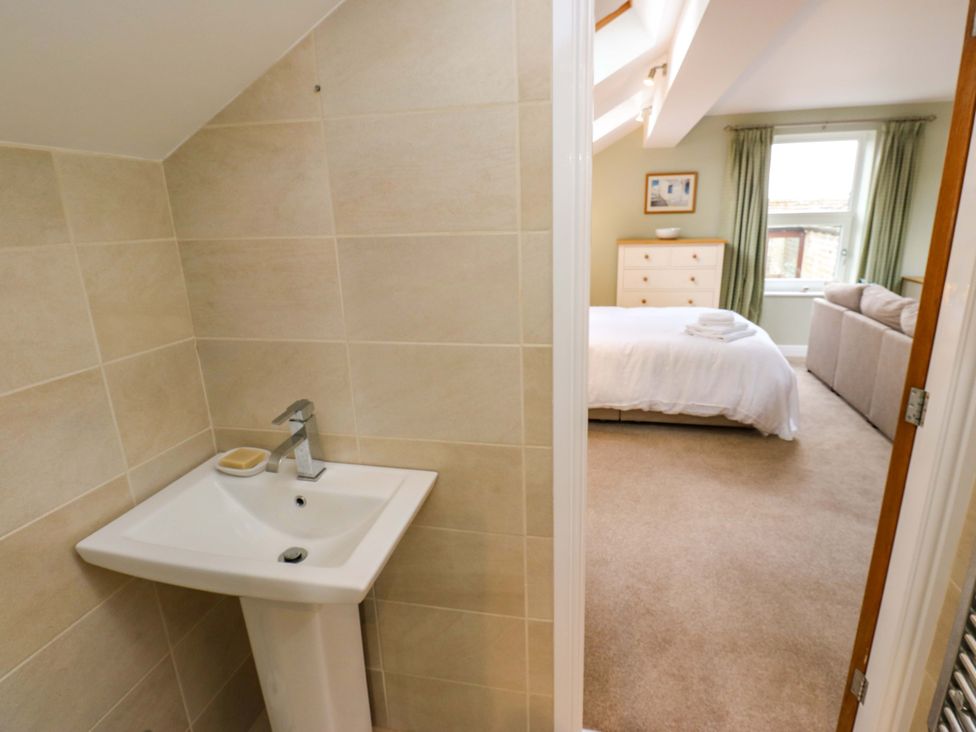 A sink and a bedroom with a bed and chest of drawers at Chapel House Annex in Scholes