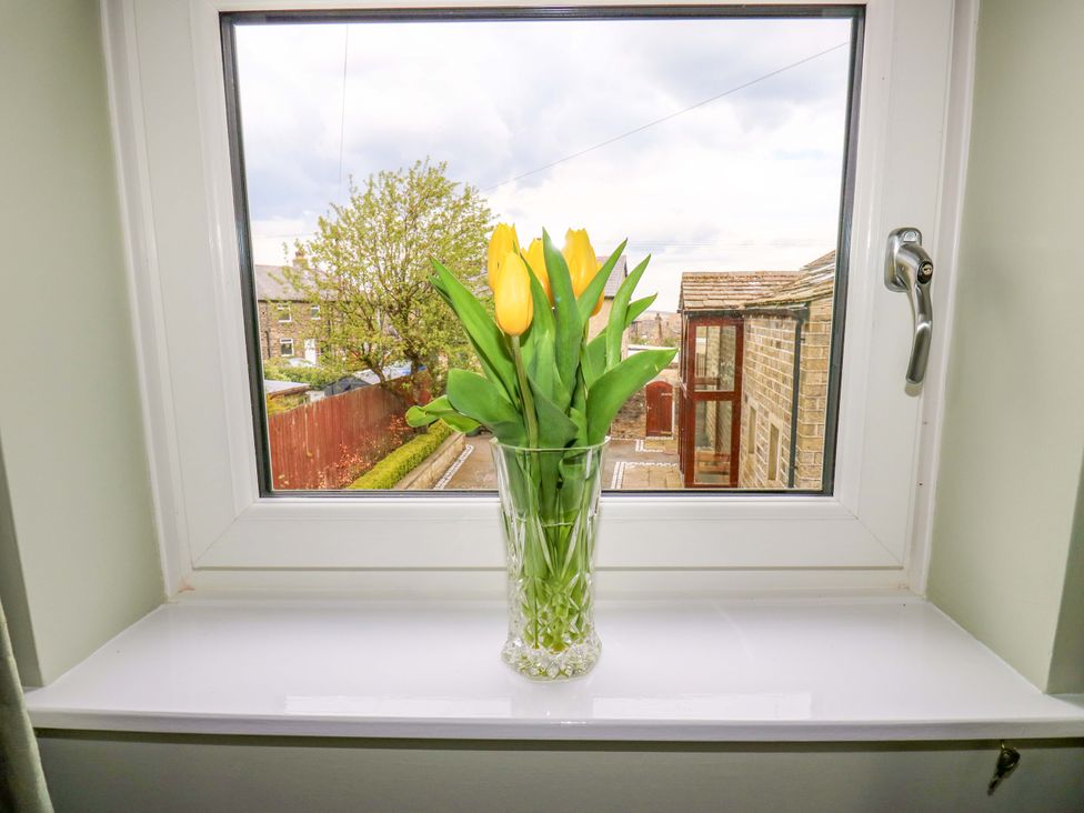 A window with a vase of flowers overlooking a garden at Chapel House Annex Scholes