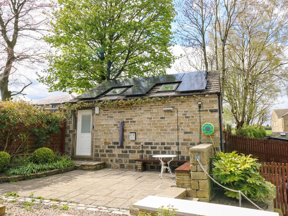 A house with a door and table in a garden at Chapel House Annex in Scholes