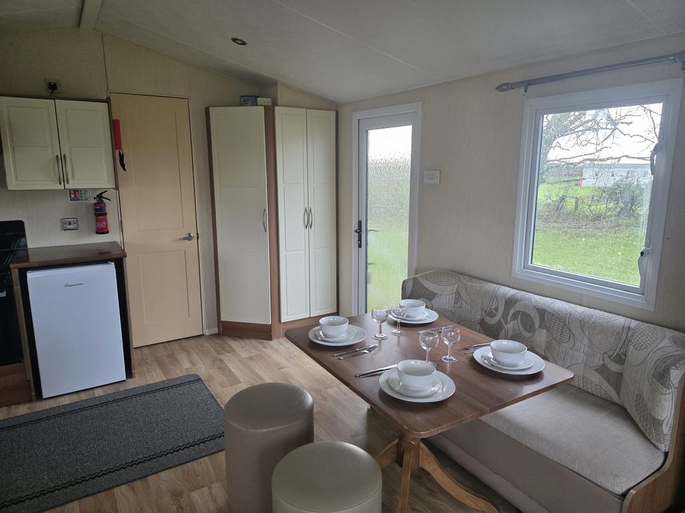 A dining area with a table set for meals at Caravan 5 at Blackmoor Farm near Tenby