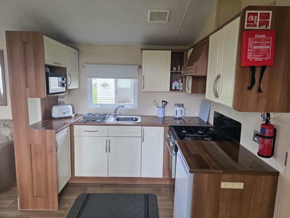 A kitchen with cabinets and appliances at Caravan 5 at Blackmoor Farm near Tenby