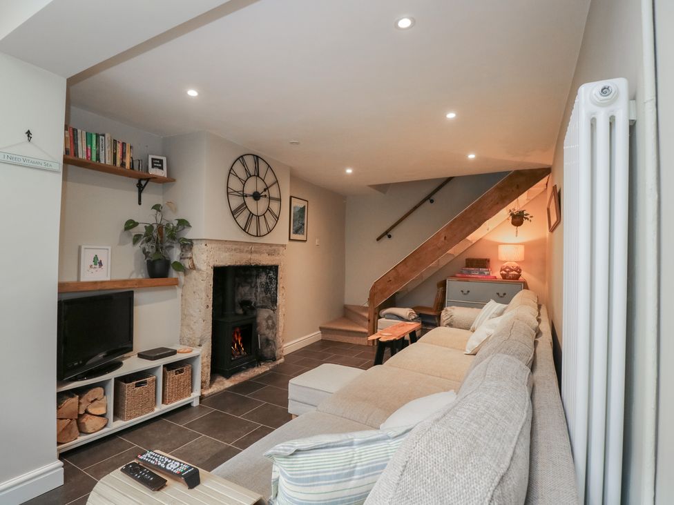 A living room with a fireplace and television at Lavender Cottage in Bradford-on-Avon