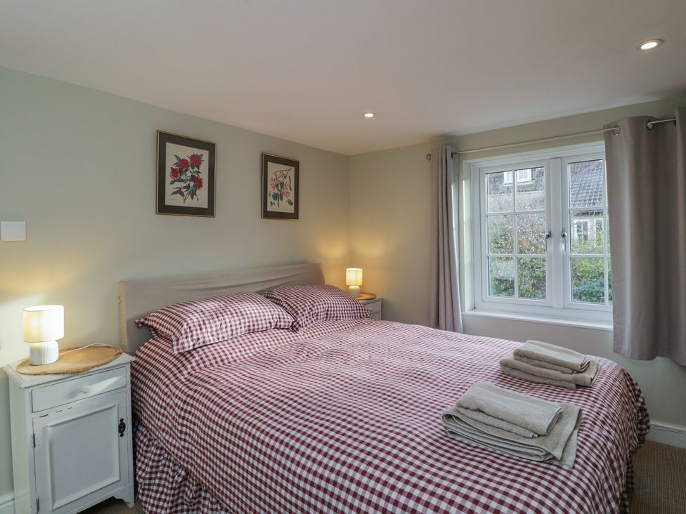 A bedroom with a double bed and framed pictures at Lavender Cottage in Bradford-on-Avon