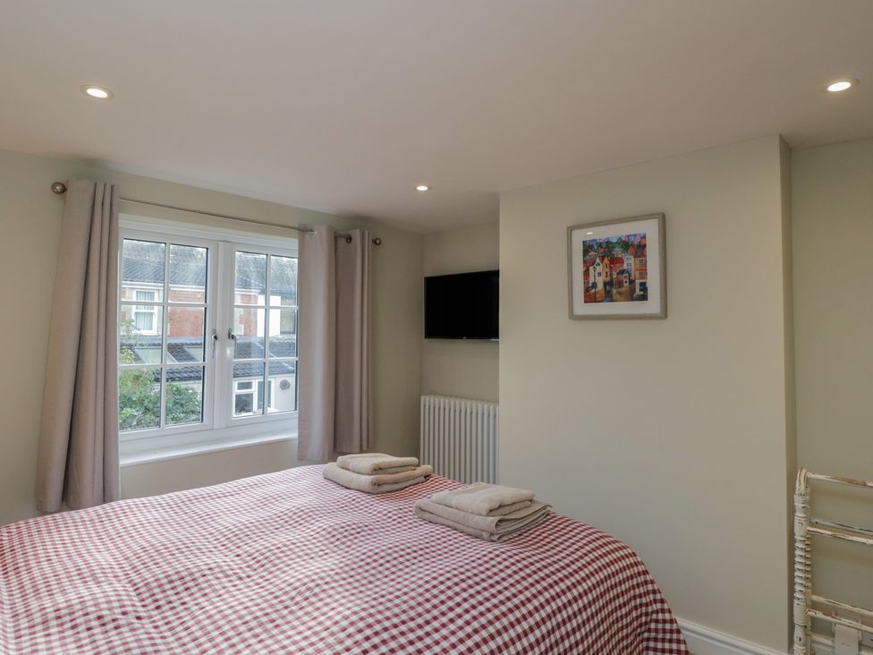 A bedroom with a bed and towels at Lavender Cottage in Bradford-on-Avon
