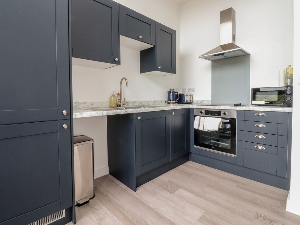A kitchen with cabinets, sink, stove, and microwave at Apartment 20, River View in Garstang