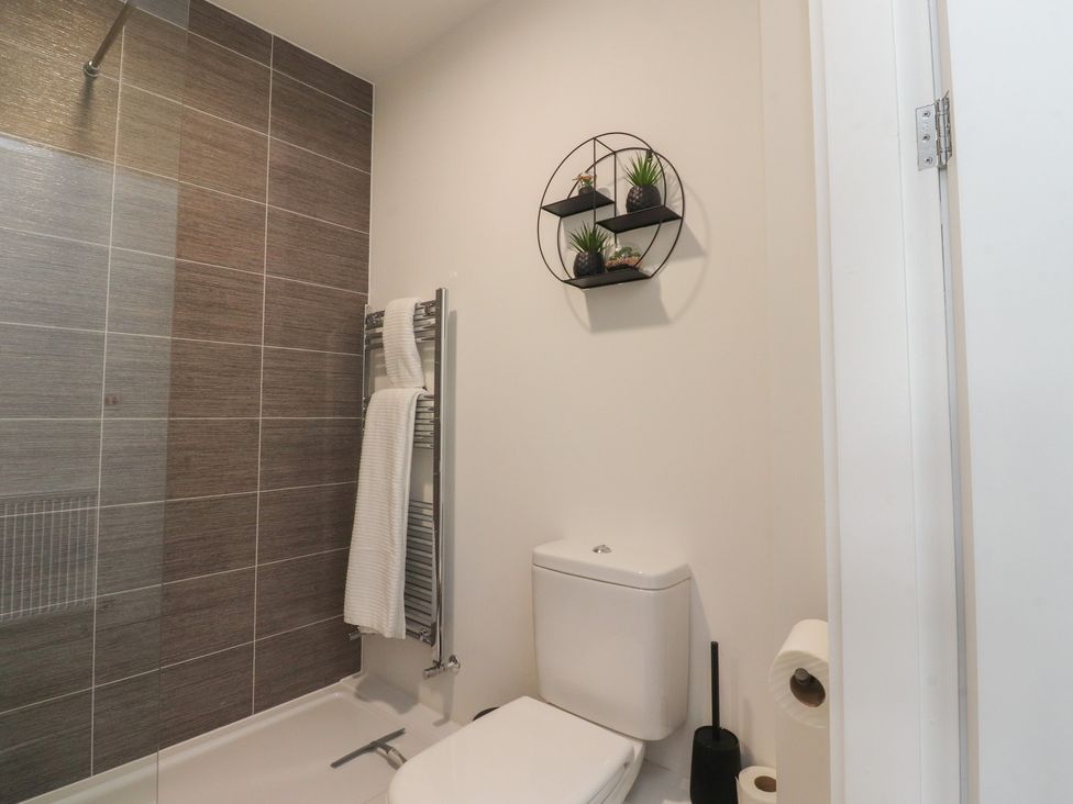 A bathroom featuring a shower, towel rail and toilet at Apartment 20, River View in Garstang