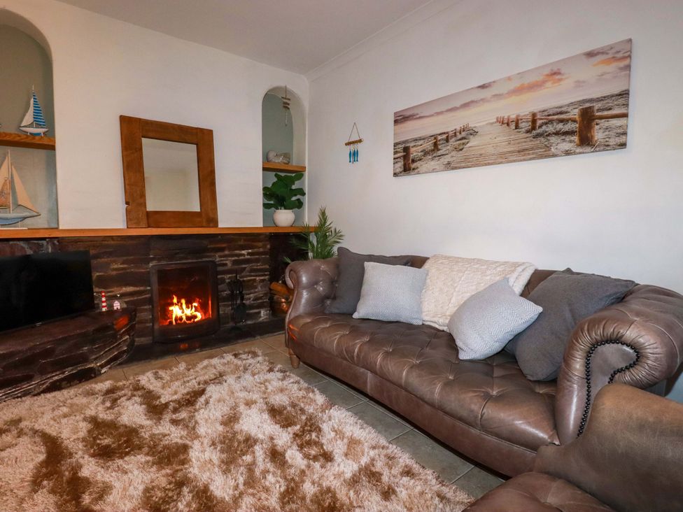 A living room with a sofa and fireplace at Chapel Cottage in Mevagissey