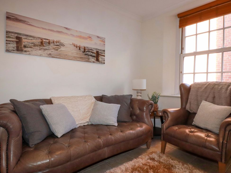 A living room with a sofa and armchair at Chapel Cottage in Mevagissey
