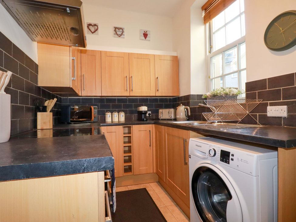 A kitchen with cabinets and appliances at Chapel Cottage in Mevagissey