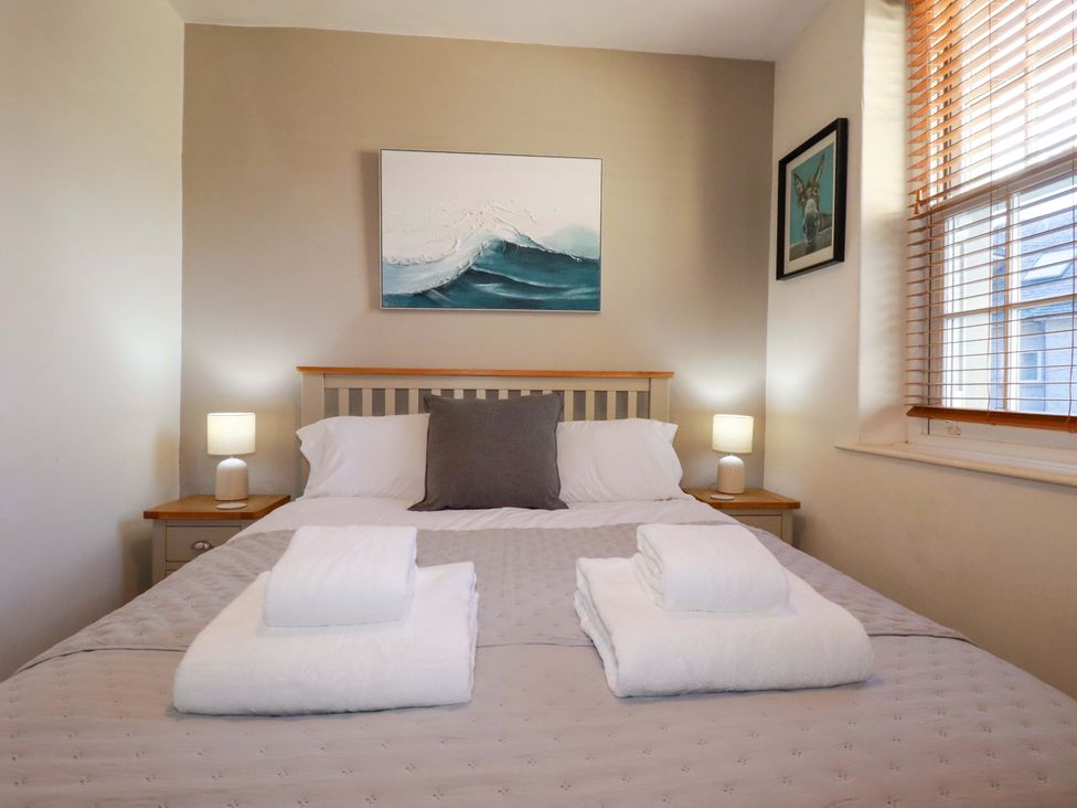 A bedroom with a bed and bedside lamps at Chapel Cottage in Mevagissey