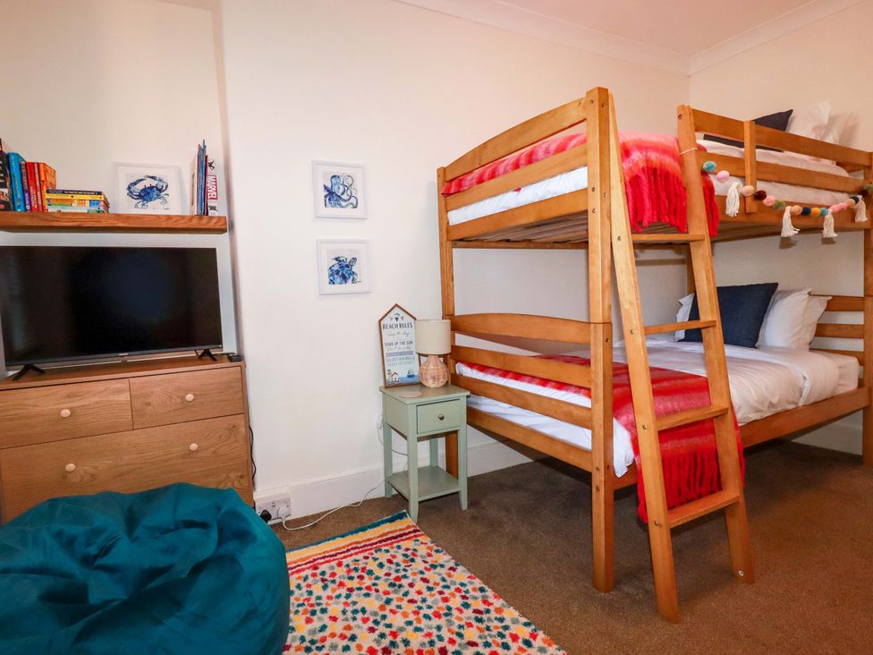 A bedroom with a bunk bed and TV at Chapel Cottage in Mevagissey