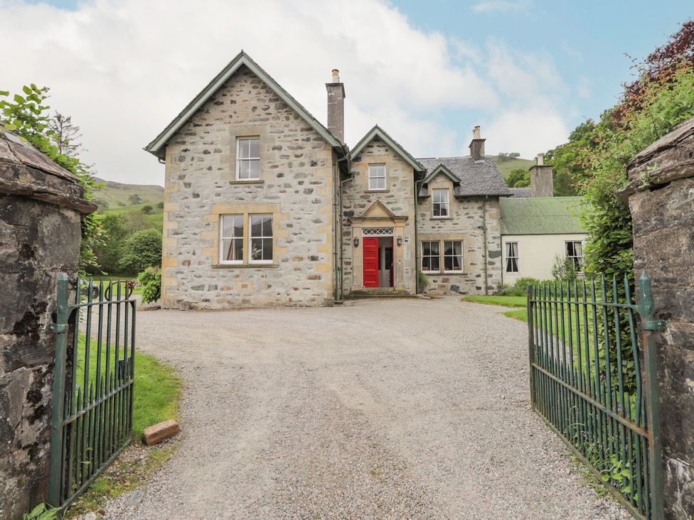 A stone house with a red door at Druidaig Lodge in Kyle