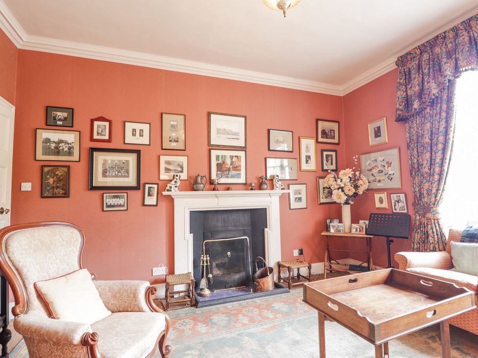 A living room with a fireplace and pictures on the wall at Druidaig Lodge in Kyle