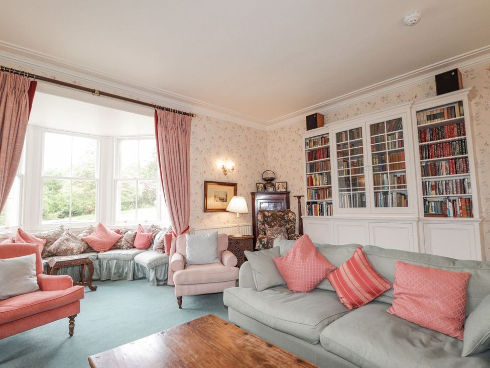 A living room with seating and a bookcase at Druidaig Lodge in Kyle