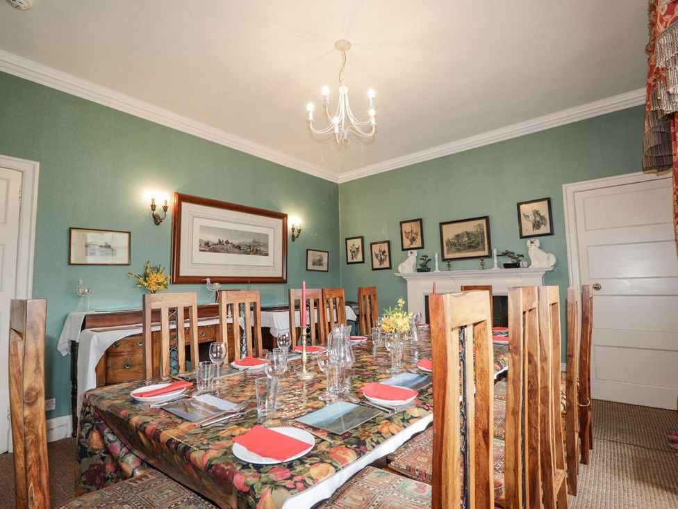 A dining room with a table set for meals at Druidaig Lodge in Kyle
