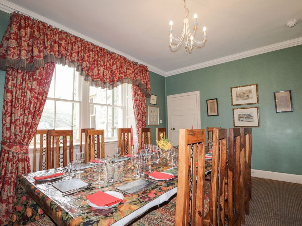 A dining room with a long table and chairs at Druidaig Lodge Kyle