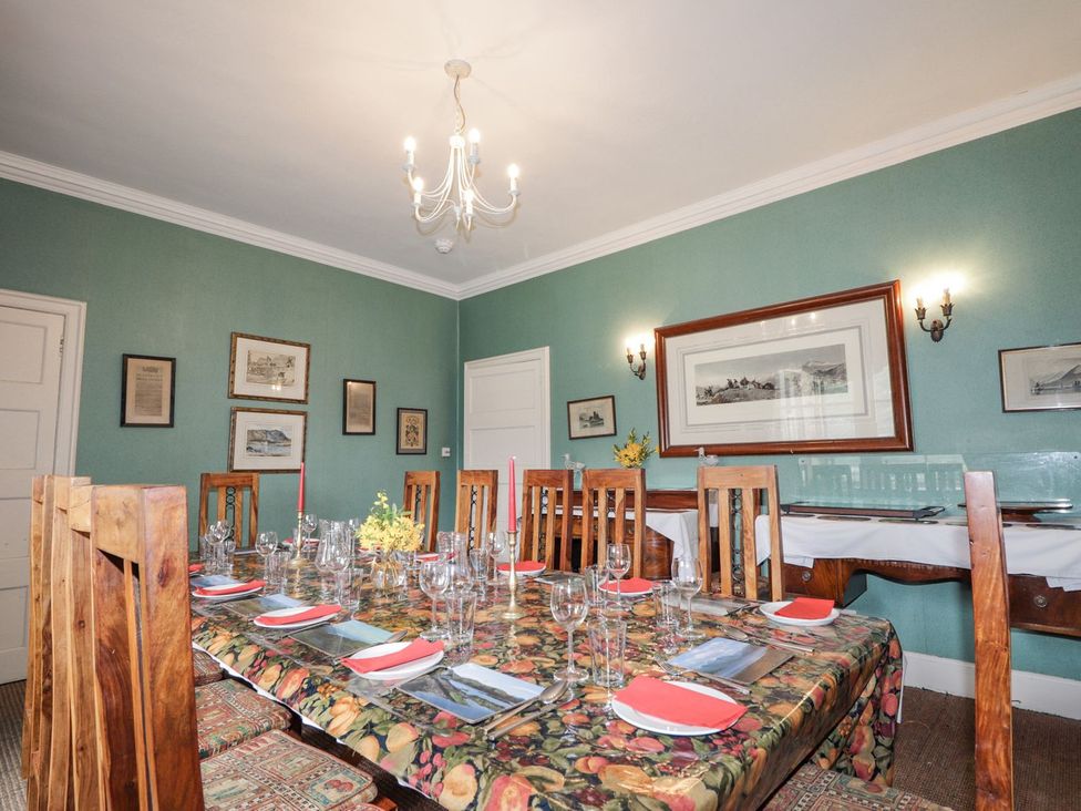 A dining room with a large table set for meals at Druidaig Lodge in Kyle