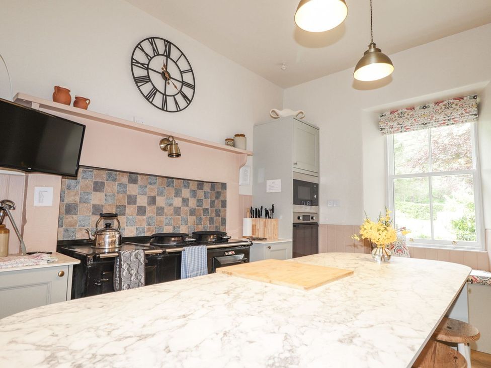 A kitchen with a stove, sink, and countertop at Druidaig Lodge in Kyle