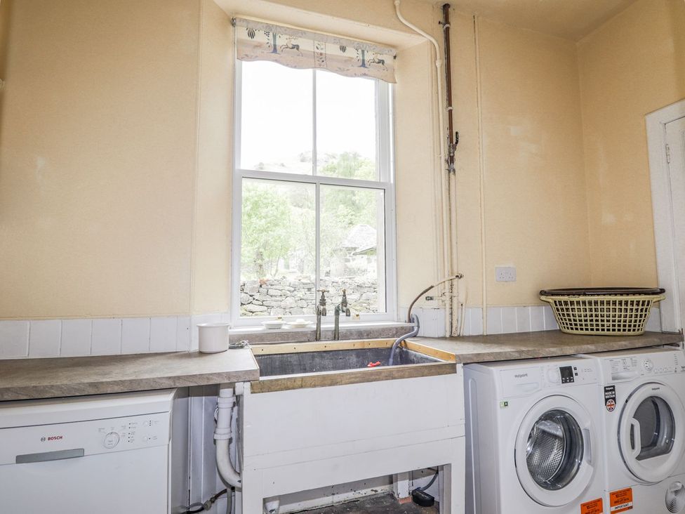A laundry room with a washing machine and sink at Druidaig Lodge in Kyle