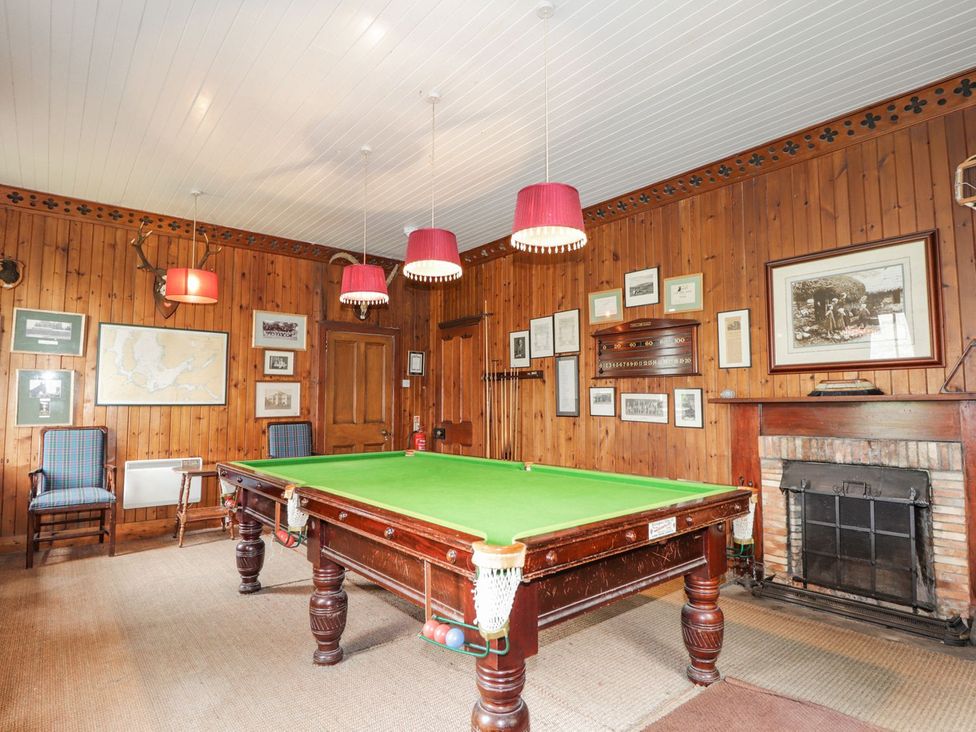 A games room with a snooker table and fireplace at Druidaig Lodge in Kyle