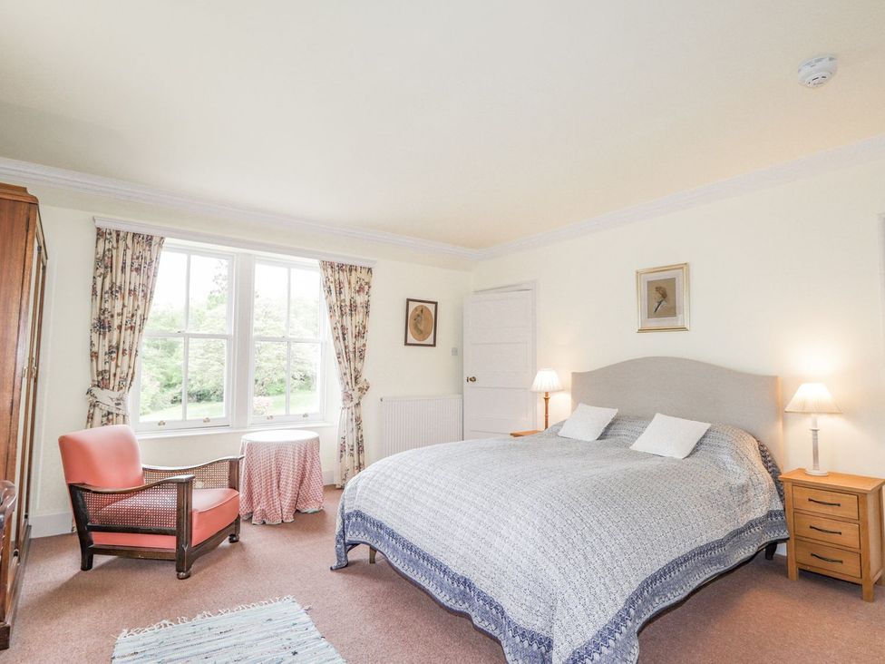 A bedroom with a bed and chair at Druidaig Lodge in Kyle