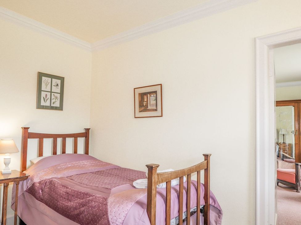 A bedroom with a single bed and wall art at Druidaig Lodge in Kyle
