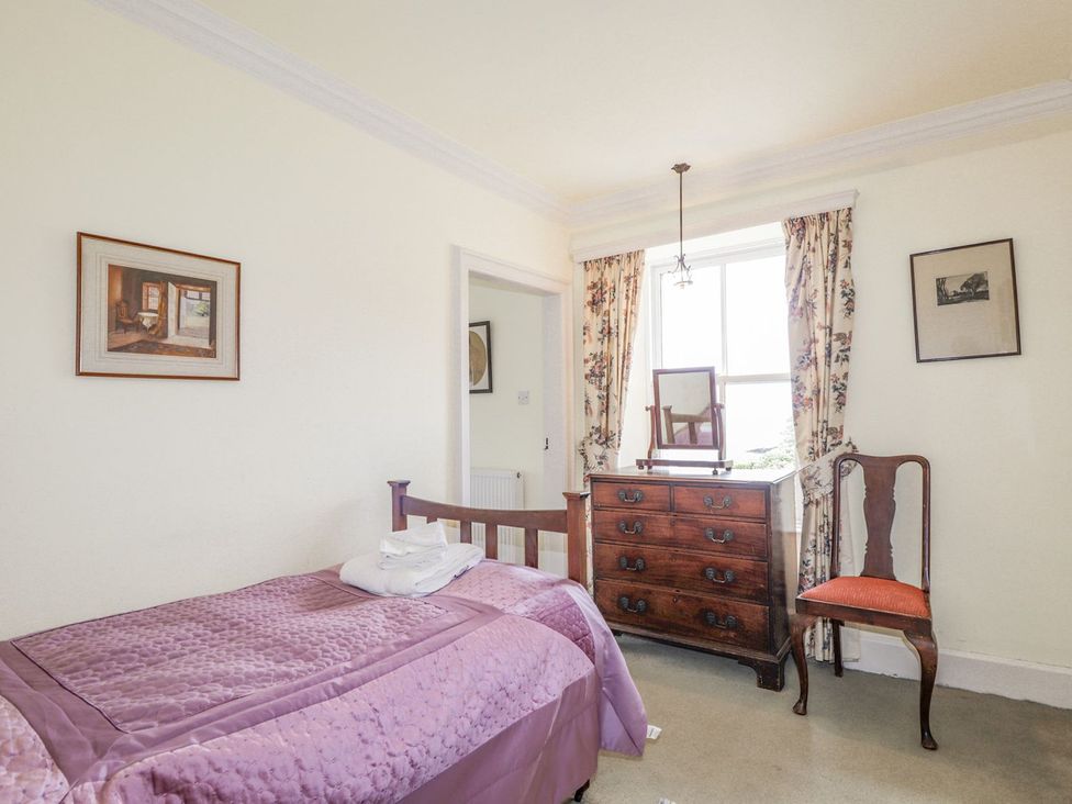 A bedroom with a bed and a dresser at Druidaig Lodge in Kyle
