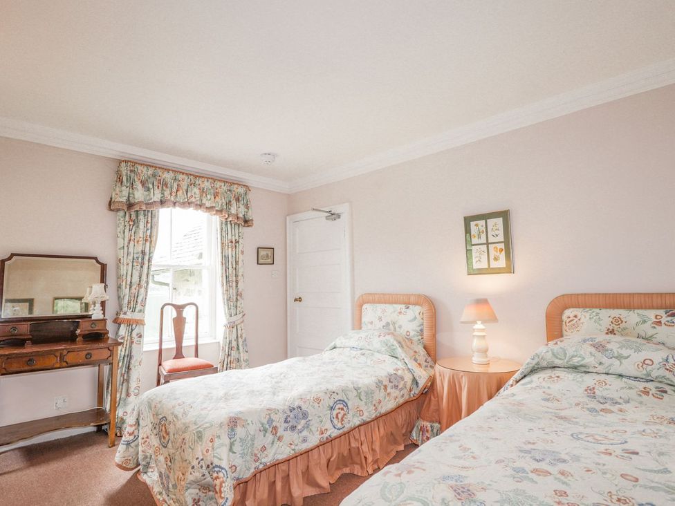 A bedroom with twin beds and a dressing table at Druidaig Lodge in Kyle