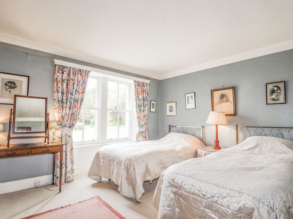 A bedroom with two beds and a mirror at Druidaig Lodge in Kyle