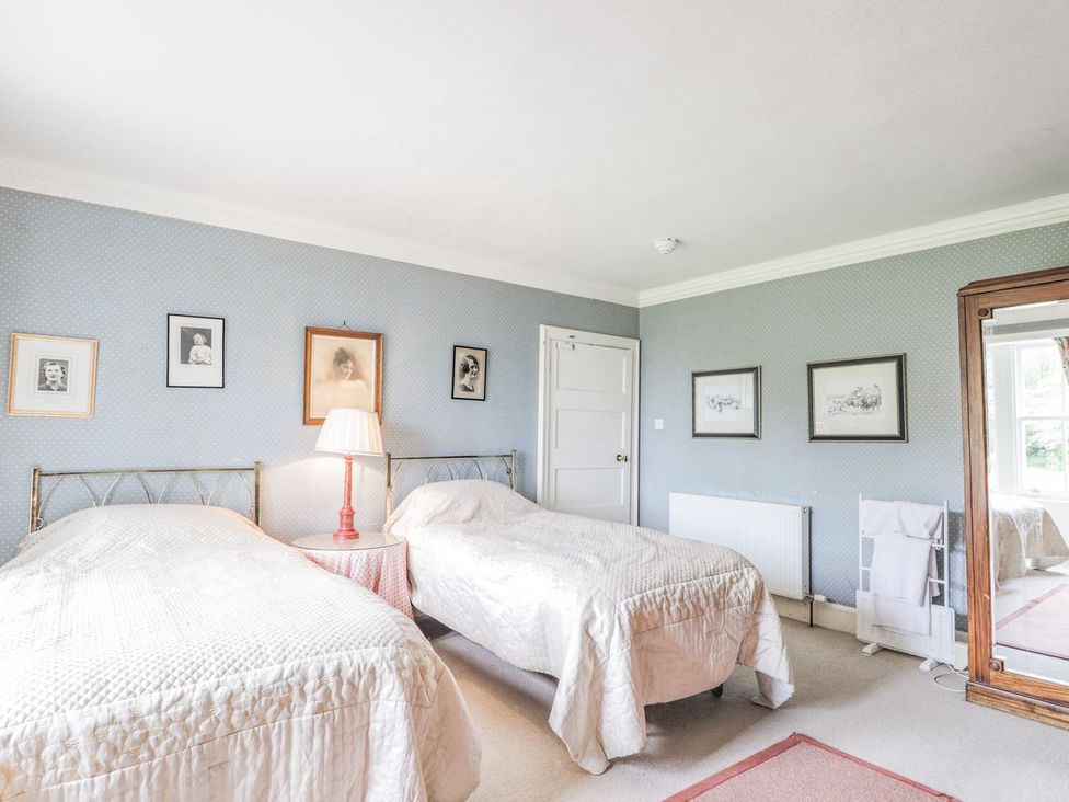 A bedroom with two beds and a mirror at Druidaig Lodge in Kyle