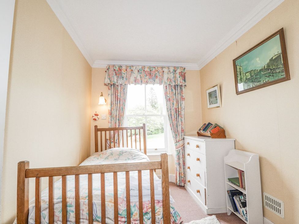 A bedroom with a bed, window, and furniture at Druidaig Lodge in Kyle